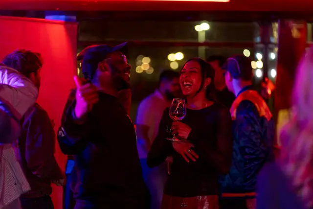 People dancing under red and blue club lights.