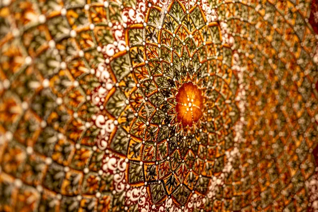 A richly patterned vaulted ceiling with hanging lights.