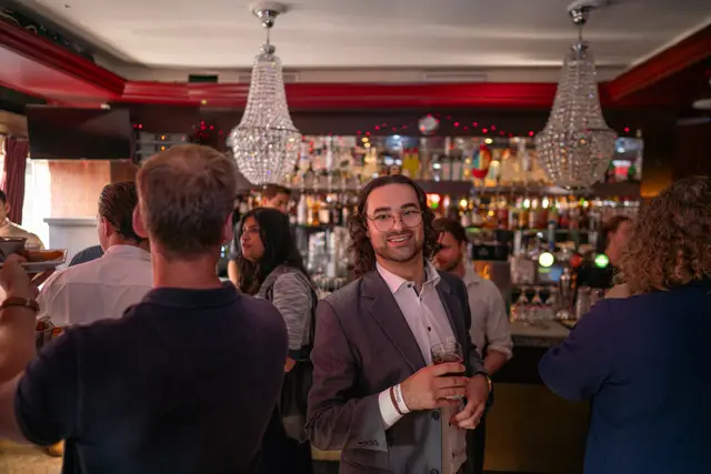 Guests mingling at an indoor networking reception.