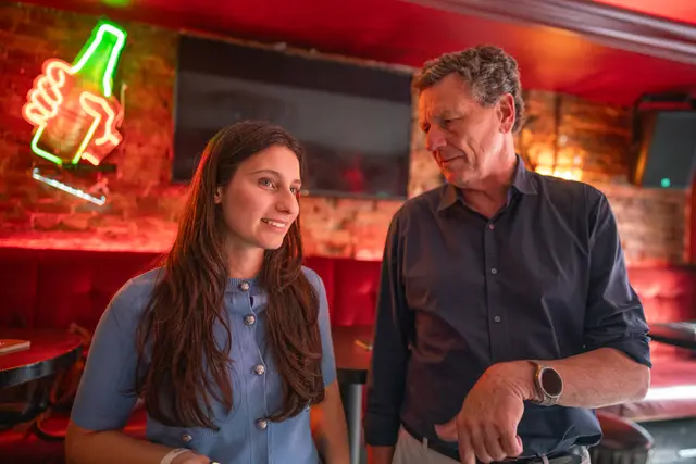 People chatting at a bar during an event.